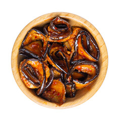 Eggplant kimchi in wooden bowl isolated on white. Top view. Traditional Korean fermented food.