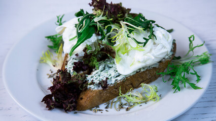 Dish for breakfast. Eggs Benedict. Toasted sandwich with poached eggs and lettuce