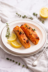 plate of grilled salmon with lemon wedges