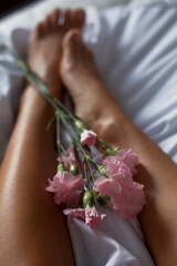 Obraz na płótnie Canvas Foot care. Women's legs and flowers