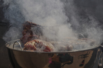 Carne asada tras humo de parrilla. 