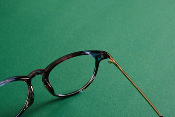 trendy modern eye glasses on green background copy space