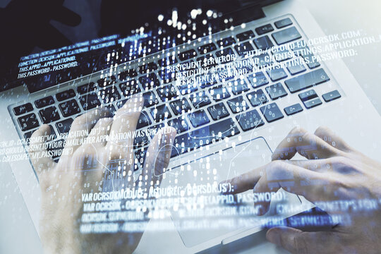 Double exposure of creative code skull hologram and hands typing on laptop on background. Malware and cyber crime concept