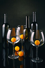 Still life with bottles, glasses and orange balls