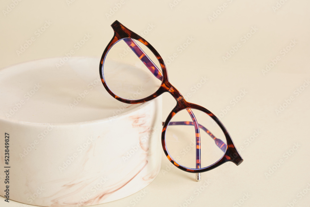 Wall mural fashion eyeglass frames, glasses on ceramic podium, creative presentation of eyeglasses