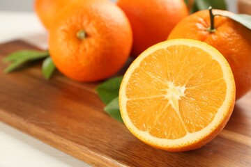 Delicious ripe oranges on wooden board, closeup