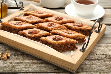 Delicious sweet baklava with walnuts on wooden table, closeup
