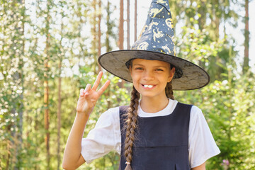 teen girl in a witch costume in the park