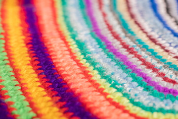 Knitted background of colored threads with background defocus. The concept of knitting warm clothes, rugs