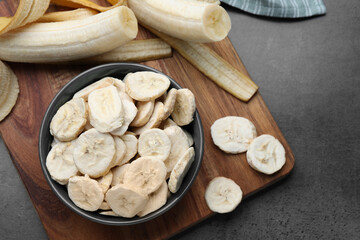 Freeze dried and fresh bananas on grey table, top view. Healthy lifestyle