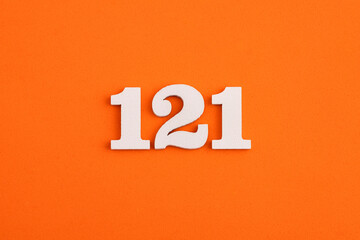 White wooden number 121 on eva rubber orange background