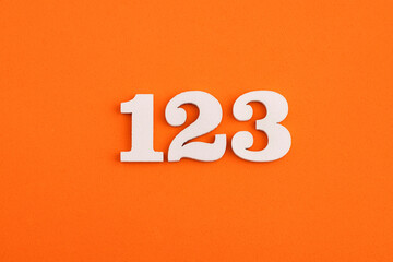 White wooden number 123 on eva rubber orange background