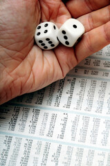 throwing dice over a stock market listing, concept for risk and gamble in financial markets