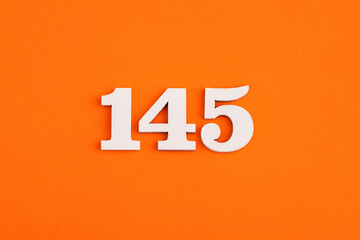 White wooden number 145 on eva rubber orange background