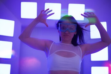 A beautiful slim woman wearing a VR headset in a futuristic setting with flares