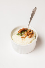 Isolated creamy rice pudding sprinkled in the cinnamon powder and top with walnuts and thyme in a...