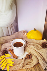 Bright composition with orange pumpkin and mug of coffee. Black coffee in a white mug with cinnamon sticks.