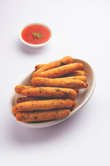 crispy Rava Aloo fingers or Potato semolina fried finger sticks served with ketchup