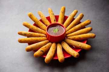 crispy Rava Aloo fingers or Potato semolina fried finger sticks served with ketchup