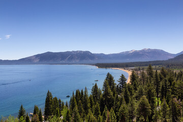 Fototapeta na wymiar Large Lake with Beach surrounded by Trees and Mountains. Summer Season. Lake Tahoe, California, United States. Nature Background.