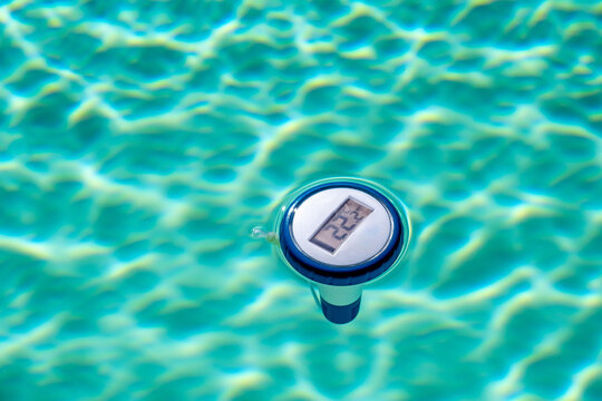 Digitales Poolthermometer schwimmt im im Pool und zeigt die Temperatur an.