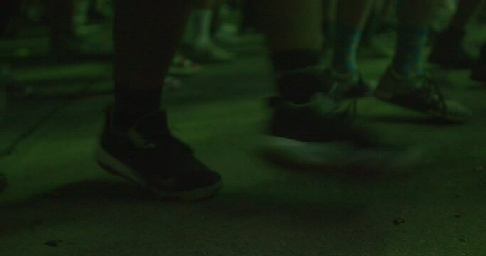 Raver's feet make dance moves on the floor. He Jumps from toe to heel, feeling the rhythm of the music. The nightclub dance floor lights are flashing. 