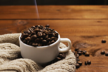 Coffee grains and tea leaves in cup on table