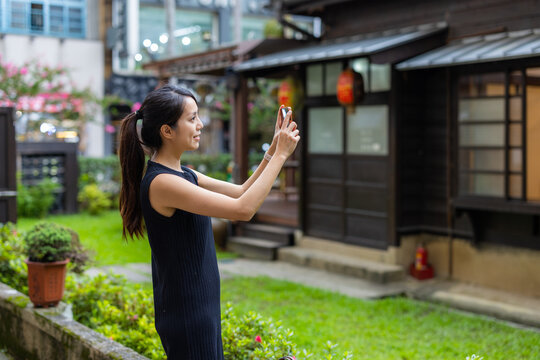 Woman use mobile phone take photo on the Japanese house