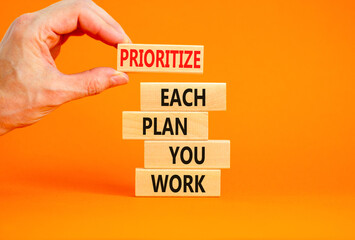 Prioritize each plan you work symbol. Concept words Prioritize each plan you work on blocks on beautiful orange background. Businessman hand. Business prioritize each plan you work concept. Copy space