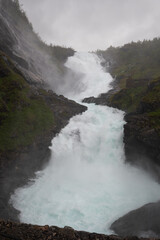 The powerful Kjosfossen waterfall roars while his water drops more than 200m down from the cliffs, Myrdal, Norway