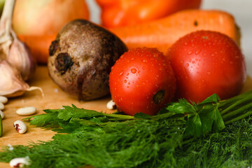 Close-up of tomatoes with various vegetables for cooking borscht.