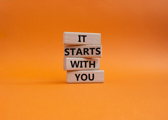 It starts with you symbol. Wooden blocks with words It starts with you. Beautiful orange background. Business and It starts with you concept. Copy space.