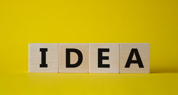 Idea symbol. Concept word Idea on wooden cubes. Beautiful yellow background. Business and Idea concept. Copy space