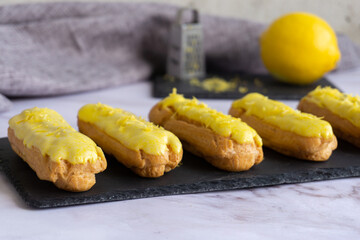 Eclair with custard and lemon glaze sprinkled with lemon zest.