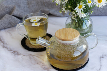 Chamomile tea. Herbal tea. Glass cup with warm fragrant chamomile tea
