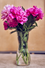 Beautiful flowers in a glass vase. A beautiful bouquet of bright pink peonies. Flower arrangement. Wallpaper, greeting card, poster, flower shop concept. High quality photo