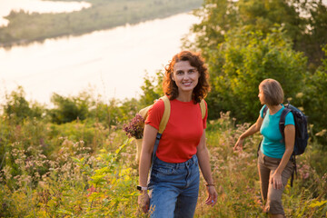 multi generation a group of women friends with backpacks hiking in nature and spending time together. travel tourism concept. Outdoor activities on weekends.