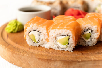 Pieces of fresh philadelphia sushi roll served on wooden board and ready to eat