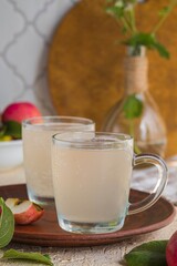 White kvass, a fermented drink made from apples in glass mugs on a light concrete background. Fermented foods, probiotics.