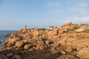 Lighthouse Men Ruz and museum Maison Littoral towering the extraordinarily colored stones and fantastically shaped rock formations at the Atlantic Ocean-pink granite coast, Brittany, France