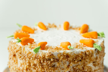 Delicious carrot cake decorated with mastic sweet carrots. Homemade carrot cake with yellow crumbs...