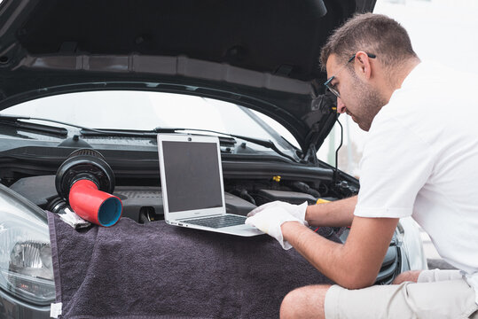 mec&aacute;nico comprobando fallos de un coche. Mec&aacute;nico arreglando coche.