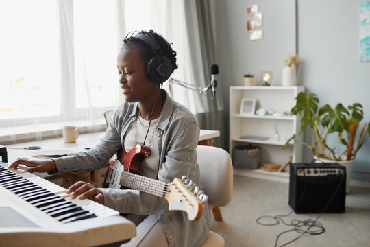 Minimal Portrait Of Young Black Woman Playing Synthesizer And Composing Music At Home, Copy Space