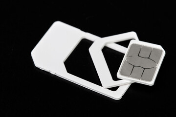 Nano SIM card extracted from sim card adaptors on dark background