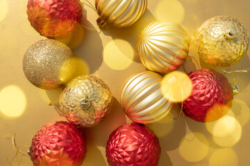 beautiful shiny gold and red Christmas baubles on a metallic golden background with bokeh lights