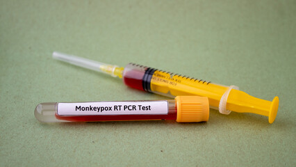Fototapeta premium Blood tests for monkeypox virus, yellow syringe and blood test tube, isolated green background