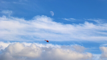 Helikopter policji polskiej  w akcji poszukiwawczej na niebie z księżycem. 
