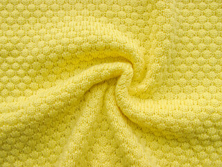 Yellow twisted knitted fabric. Fine knit yellow cloth texture. Fashion background. Jersey knit...