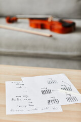 Vertical background image of music composition sheets on table in home interior, copy space