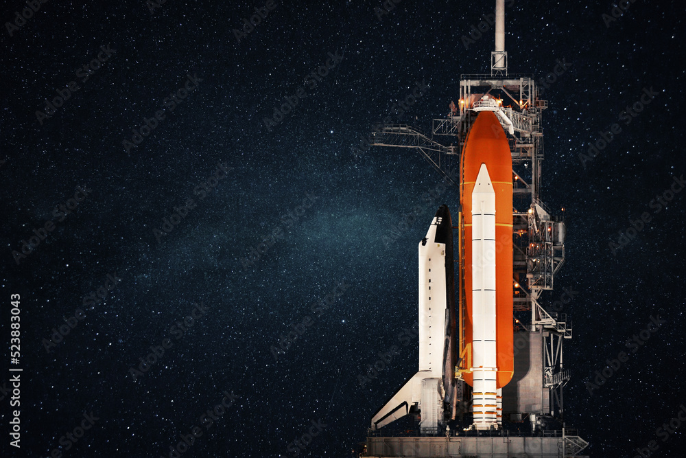 Poster space shuttle stands at the base and prepares to launch against the background of the starry sky. sp